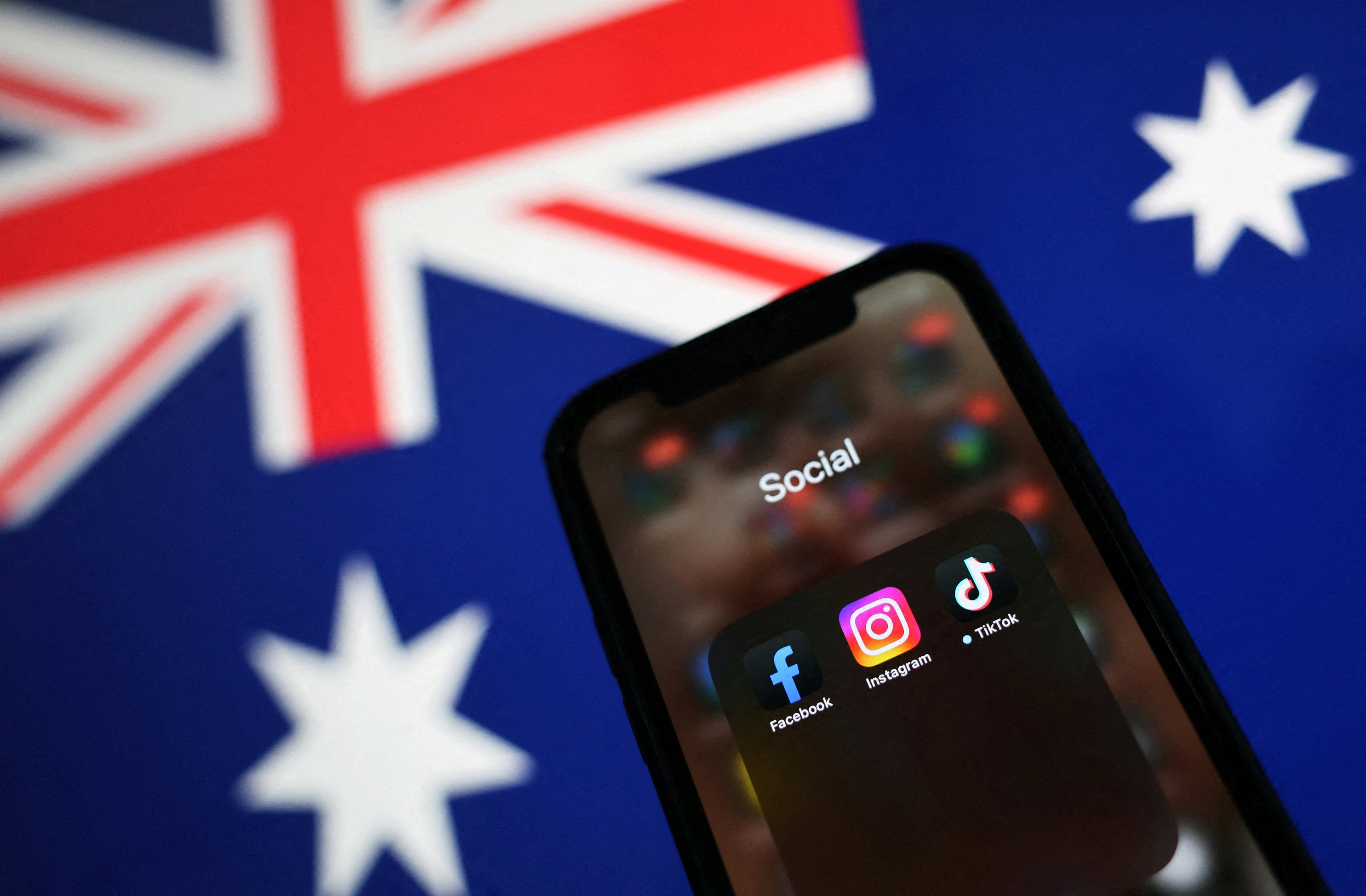 Redes sociales en un móvil, con la bandera australiana al fondo.