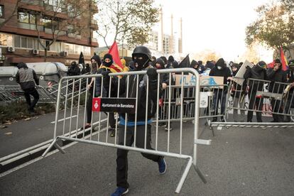 Un manifestante de los CDR en Parallel (Barcelona), levanta una valla de seguridad. 