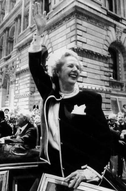 La primera ministra del Reino Unido, Margaret Thatcher, saluda a la multitud en Downing Street y Whitehall, en Londres, acompañada por su marido Denis (izquierda, detrás), a su regreso a la residencia del Primer Ministro tras las elecciones generales celebradas en el país, ganadas de nuevo por el Partido Conservador, 12 de junio de 1987.