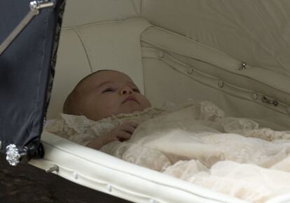 Carlota, en su cochecito y vestida para su bautismo.