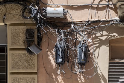 Cajas y cables de compañías de telecomunicaciones sobre una fachada, esta semana en Barcelona.