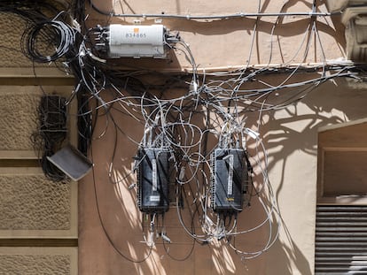 Cajas y cables de compañías de telecomunicaciones sobre una fachada, esta semana en Barcelona.