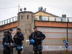 Policías italianos frente a la prisión de San Vittore, mientras se ve atrás a los detenidos protestando en el tejado de la prisión en Milán (Italia)
