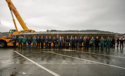 El delegado y la subdelegada del Gobierno en Galicia, Javier Losada y Maica Larriba, acompañados de diversos mandos policiales, ante el narcosubmarino hundido en Cangas (Pontevedra) tras ser reflotado por dos grandes grúas.