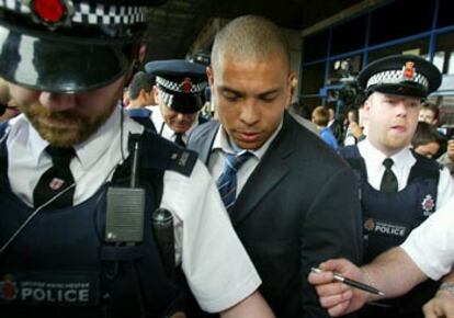 Ronaldo, protegido por policías, ayer a su llegada a Manchester.