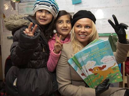 Pamela Anderson, junto a dos ni&ntilde;as en el campo de refugiados en Francia. 