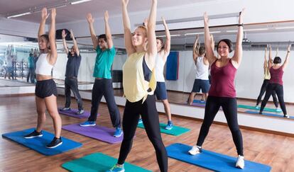 Seis personas, durante una clase en un gimnasio.