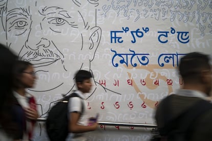 Jóvenes pasan frente a uno de los murales del pabellón de la India.