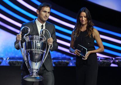 El jugador del Chelsea Frank Lampard sujeta el trofeo de la Liga de Campeones junto a la actriz suiza Melanie Winiger.