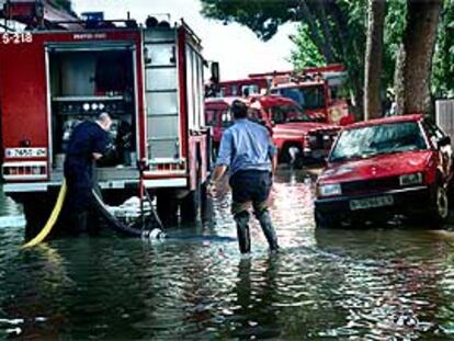 Los bomberos achicaban ayer agua en uno de los márgenes de la autopista.