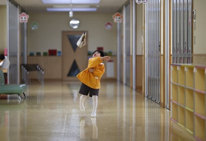 Un niño juega con un avión de papel en uno de los pasillos de la escuela infantil 'Emporium' en Koriyama (Japón).