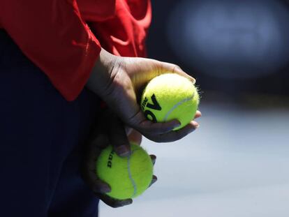 Un recogepelotas sujeta dos bolas durante un partido en Melbourne.