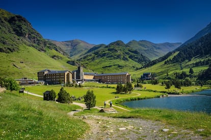 ¿Alguien se imagina un Shangri-La en medio de los Pirineos? Un lugar apartado de todo, sin coches, sin carreteras de acceso, pero al que además se puede llegar fácilmente. Lo encontramos en la Vall de Núria, un valle a 2.000 m de altitud, al que se llega por un tren-cremallera en un vertiginoso recorrido… o a pie. No hay otra forma porque no existe ninguna carretera de acceso. El tren-cremallera parte de Ribes de Freser y en un vertiginoso y espectacular recorrido recorre 12,5 kilómetros, superando un desnivel de más de 1.000 metros. Al llegar arriba esperan un santuario en el que se venera a la virgen de Núria, un enorme lago central, una pequeña pista de esquí... ¡y ni un solo vehículo motorizado! La otra forma de acceso es a pie, por uno de los empinados senderos que parten del pueblo de Queralbs y de otros puntos de la Vall de Ribes. Para disfrutar a fondo del valle prácticamente sin gente, una buena opción es pasar una noche en el Hotel Vall de Núria, contiguo al santuario y completamente renovado. Así podremos disfrutar del ocaso en compañía de un silencio estremecedor y ver la salida del sol tras las montañas antes de la llegada de los primeros visitantes a bordo del tren-cremallera. <BR></BR> Más información: valldenuria.cat