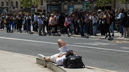 Varias personas esperan el lunes la llegada de un autobús tras el apagón eléctrico en Madrid.