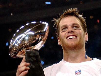 FILE - New England Patriots quarterback Tom Brady holds the Vince Lombardi Trophy after the Patriots beat the Carolina Panthers 32-29 in Super Bowl XXXVIII in Houston, Feb. 1, 2004. Tom Brady has retired after winning seven Super Bowls and setting numerous passing records in an unprecedented 22-year-career. He made the announcement, Tuesday, Feb. 1, 2022, in a long post on Instagram. (AP Photo/Dave Martin, File)
