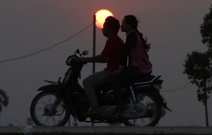 Una pareja viaja en moto por el pueblo de Kamreang a las afueras de Phnom Penh, Camboya.