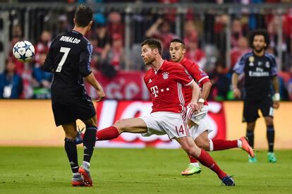 El centrocampista del Bayern Xabi Alonso (c) y el delantero del Madrid Cristiano Ronaldo en un momento del partido. 