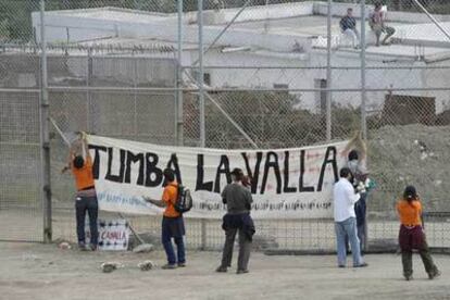 Los manifestantes depositan flores y cuelgan una pancarta en la valla fronteriza de Ceuta.