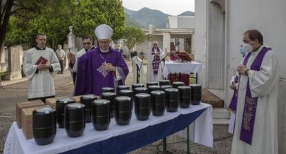 El obispo de Brescia, Pirerantonio Tremolada, bendice las urnas de un grupo de fallecidos por covid-19.