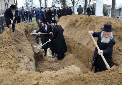 Rabinos procedentes de Gran Bretaña y EE UU esparcen tierra sobre los restos de 40 judíos asesinados durante el Holocausto.