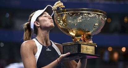 Muguruza se dispone a besar del trofeo del Abierto de Pek&iacute;n.