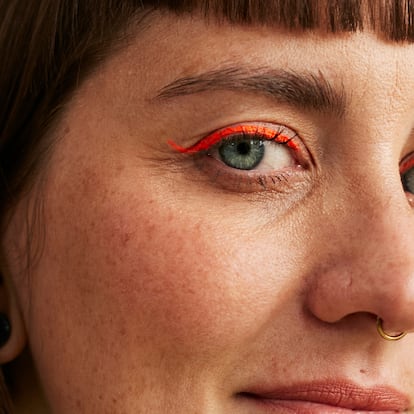 Una chica con eyeliner naranja.