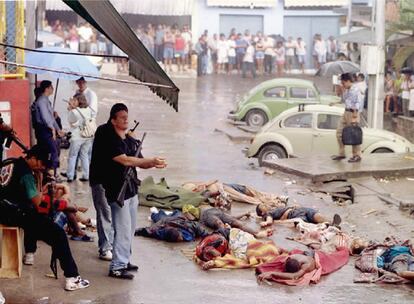 Un policía se lava la sangre en agua de lluvia, junto a los cuerpos de 14 sospechosos de narcotráfico, muertos durante un tiroteo en la favela de Nova Brasilia. Mayo de 1995