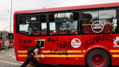 Una manifestante pinta consignas a un transporte del sistema Transmilenio durante la protesta de este jueves.