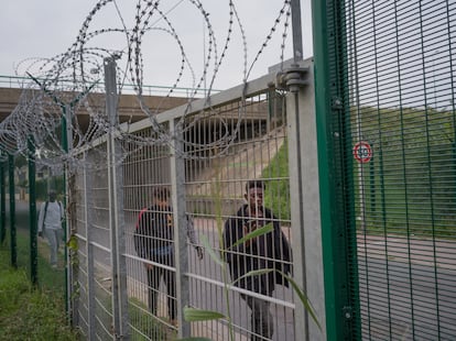 Un grupo de inmigrantes caminan junto a las alambradas que rodean las zonas portuarias en Calais.