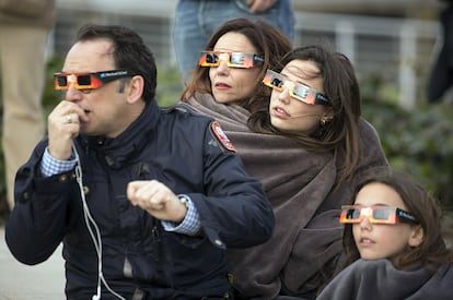 Uma família contempla ou eclipse solar em Madri.