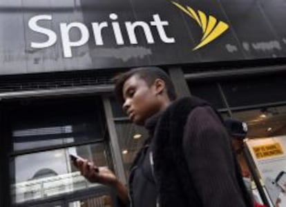 Una mujer utiliza su m&oacute;vil frente a una tienda de Sprint en Nueva York.