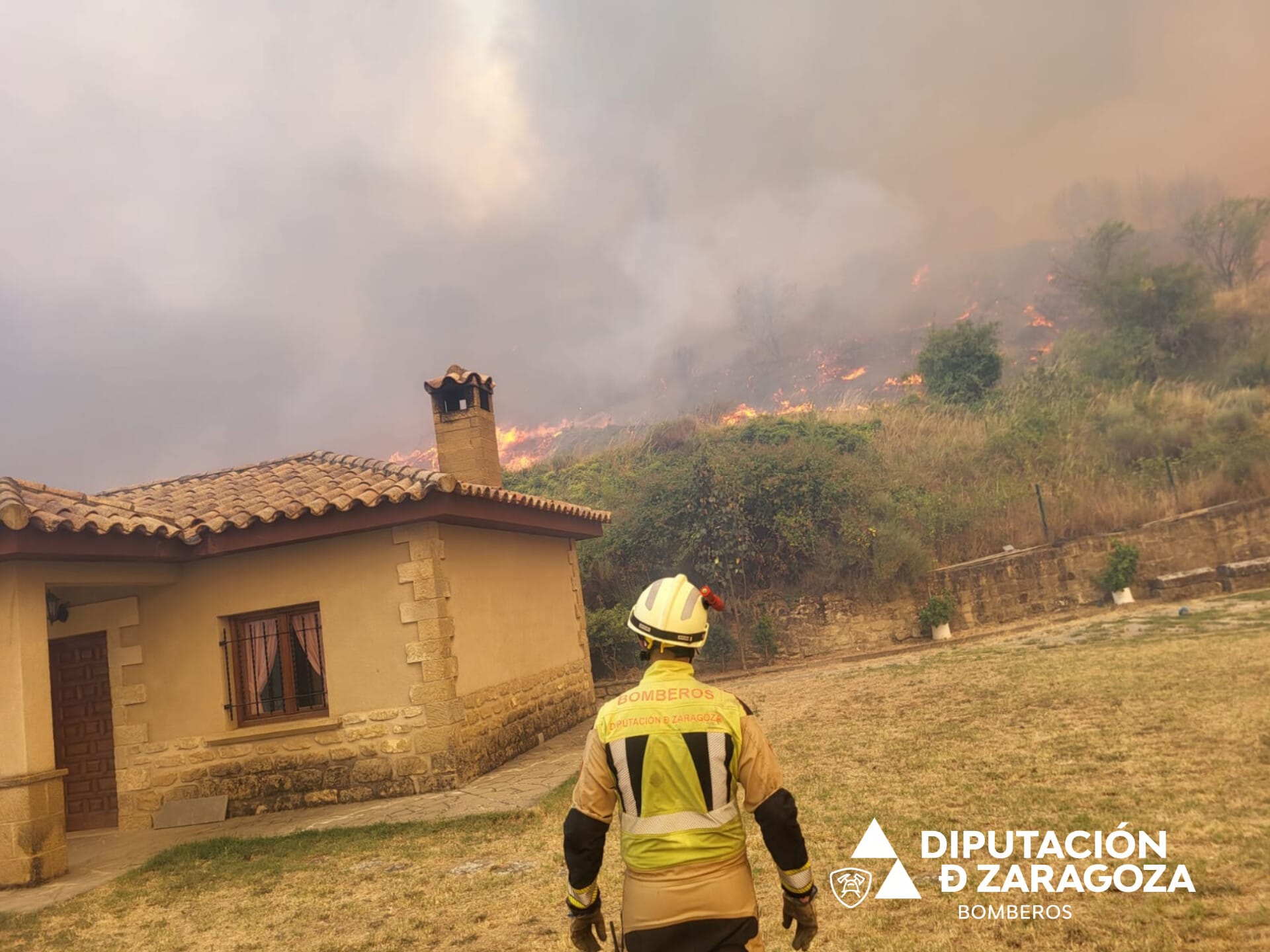 Bomberos de la Diputación de Zaragoza defendiendo el casco urbano de Uncastillo ante la proximidad de las llamas.