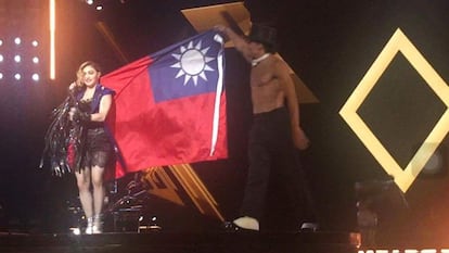 Madonna, sostiene la bandera de Taiwán durante su concierto en Taipei.