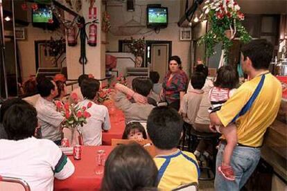 Aficionados al fútbol siguen un partido en un bar.
