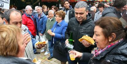 Asistentes al mercado de Santo Tomás en Bilbao degustan talo.