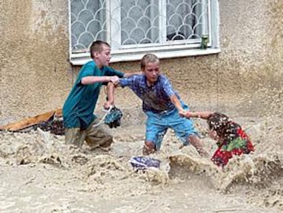 Niños intentan evitar ser arrastrados por las aguas en una calle de la ciudad de Novorosiisk.