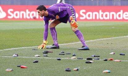 El guardameta del Osasuna, Sergio Herrera, retira las carteras lanzadas por los aficionados al terreno de juego en protesta al club.