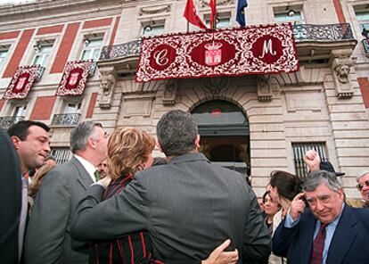 Esperanza Aguirre, junto a Alberto Ruiz-Gallardón (ambos de espaldas) contemplan la sede del Gobierno regional en la Puerta del Sol.