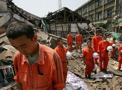 Miembros de la policía paramilitar de rescate guardan tres minutos de silencio entre las ruinas de Tashui, en la provincia de Sichuan.