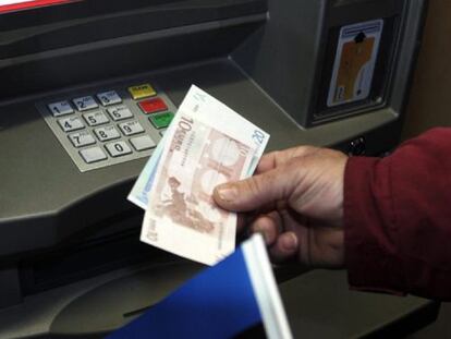 Un hombre retira dinero de un cajero automático.
