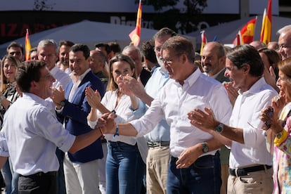 El líder del Partido Popular, Alberto Núñez-Feijóo, saluda al alcalde de Madrid, José Luis Martínez-Almeida (izquierda), durante el acto del PP celebrado en Madrid. 
