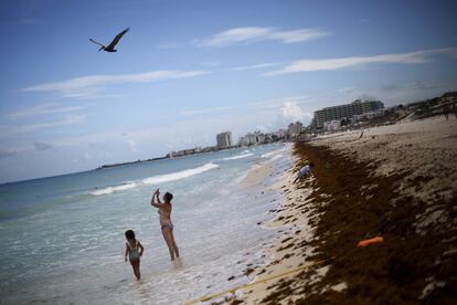 A woman takes pictures on a beach in Cancun, August 15, 2015. In the high season from about December to early April, tourists from the United States, Europe and further afield crowd the resort to swim and snorkel off usually pristine white beaches, party in the resort's many nightclubs and play golf.  REUTERS/Edgard Garrido PICTURE 9 OF 34 FOR WIDER IMAGE STORY 'EARTHPRINTS: CANCUN'SEARCH 'EARTHPRINTS CANCUN' FOR ALL IMAGES