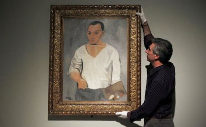 A gallery employee adjusts Picasso&#039;s &#039;Self-portrait with palette&#039; at the Fundaci&oacute;n Mapfre exhibition in Madrid.  