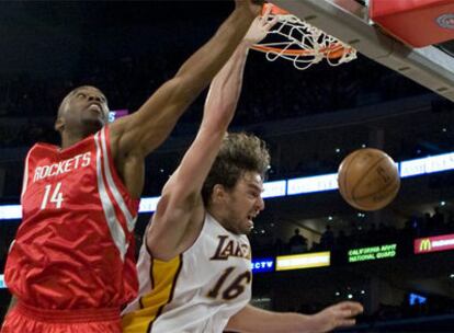 Pau Gasol realiza un mate frente al jugador de los Rockets Carl Landry
