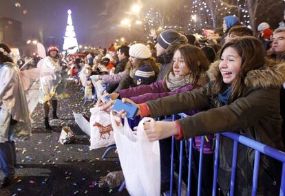 Varias niñas extienden bolsas para coger caramelos al paso de la Cabalgata de los Reyes Magos de Oriente, Melchor Gaspar y Baltasar, por el Paseo de la Castellana, hoy en Madrid. La comitiva real, dedicada este año a la magia, ha salido a las seis y media de la tarde de Nuevos Ministerios para terminar su recorrido en la céntrica Plaza de Cibeles.