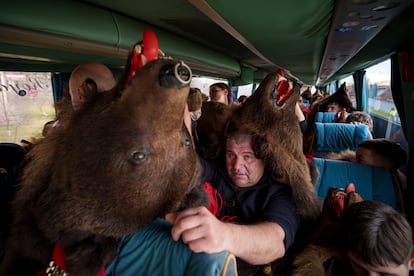 A member of the Sipoteni bear pack sits on a bus in Racova, northern Romania, Tuesday, Dec. 26, 2023, while touring villages to perform the bear dance ritual.