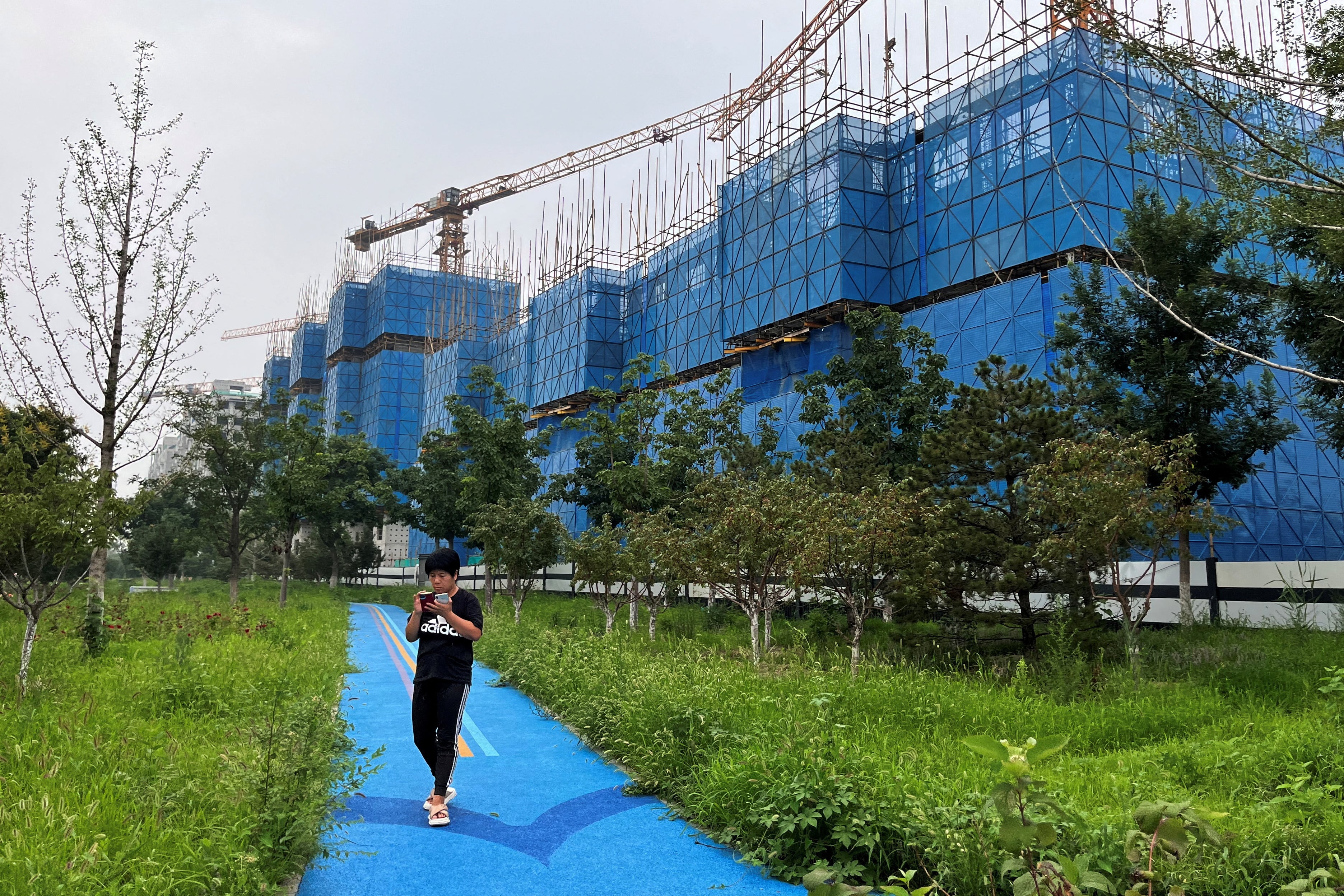 Una persona camina junto a un eficio en construcción de la inmobiliaria Country Garden, en Pekín, el pasado 11 de agosto.