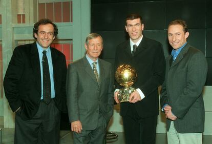 O jogador francês Zinedine Zidane sorri enquanto segura a Bola de Ouro que recebeu em 1998, junto de Michel Platini, Raymond Kopa e Jean-Pierre Papin.