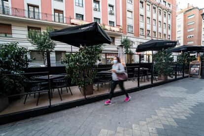 Una mujer pasa junto a una terraza en la calle Gaztambide, en Madrid; el 1 de febrero de 2022.