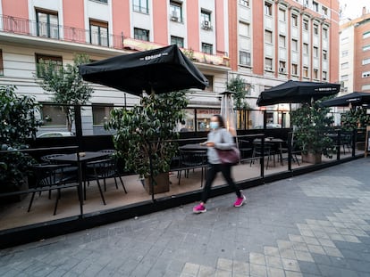 Una mujer pasa junto a una terraza en la calle Gaztambide, en Madrid; el 1 de febrero de 2022.